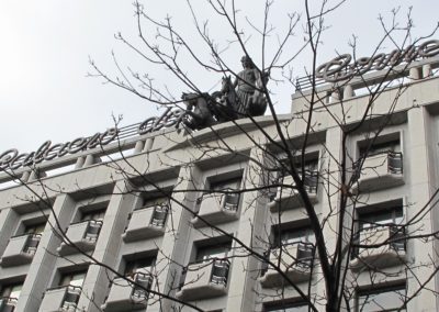 Cimo da fachada do Palácio do Comércio, com o letreiro e o grupo escultórico sobre a cornija
